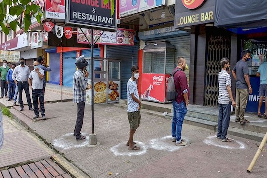 Guwahati: People maintain social distance as they stand in a queue to buy alcohol from a wine shop, during the ongoing COVID-19 pandemic, in Guwahati, Saturday, May 2, 2020. (PTI Photo)(PTI02-05-2020_000233B)