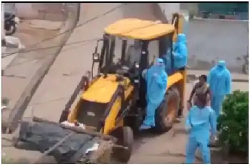 माणुसकी मेली! कोरोना रुग्णाचा मृतदेह जेसीबीमध्ये फेकला, मन हेलावणारा VIDEO आला समोर