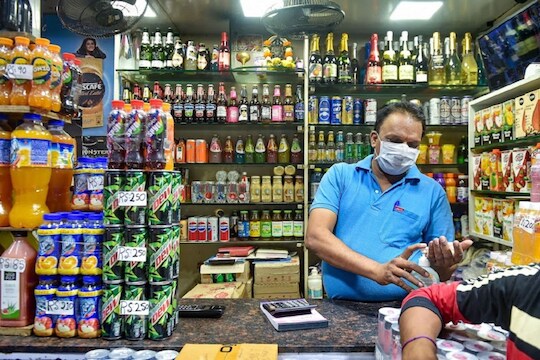 Mumbai: A shopkeeper wears a mask and sanitize his hands in the wake of deadly coronavirus, at Crawford market in Mumbai, Wednesday, March 18, 2020. (PTI Photo/Mitesh Bhuvad) (PTI18-03-2020_000222B)