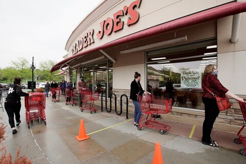 Customers observe social distancing as they wait to be allowed to shop at a Trader Joe's supermarket in Omaha, Neb., Thursday, May 7, 2020. Store workers across the country are suddenly being asked to enforce the rules that govern shopping during the coronavirus pandemic.(AP Photo/Nati Harnik)