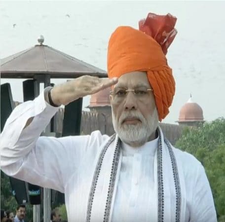2018मध्ये पीएम मोदींना पांढरा कुर्ता-पायजमा आणि लाल बांधणीची किनार असलेली भगव्या रंगाची पगडी परिधान केली होती. 2018मध्ये पीएम मोदींना पांढरा कुर्ता-पायजमा आणि लाल बांधणीची किनार असलेली भगव्या रंगाची पगडी परिधान केली होती.