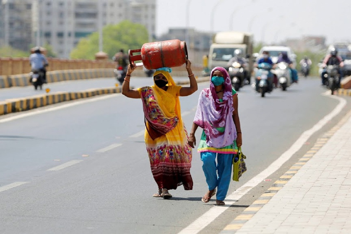 Ahmedabad: A woman carries a cooking gas cylinder on her head as she walks on a bridge during the ongoing nationwide COVID-19 lockdown, in Ahmedabad, Saturday, May 9, 2020. (PTI Photo)(PTI09-05-2020_000089B)