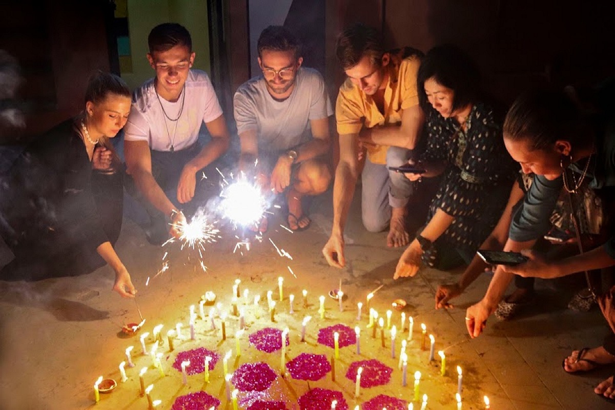 Varanasi: Foreign tourists light candles and burn crackers during Diwali celebrations, in Varanasi, Sunday, Oct. 27, 2019. (PTI Photo)(PTI10_28_2019_000044B)