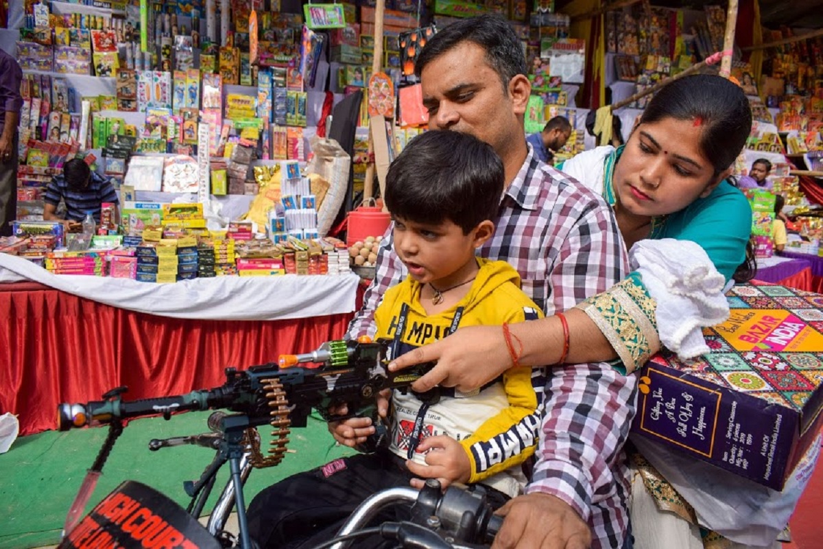 Allahabad: A family purchases firecrackers at a market, ahead of the festival of Diwali, in Allahabad, Saturday, Oct. 26, 2019. (PTI Photo)  (PTI10_26_2019_000034B)
