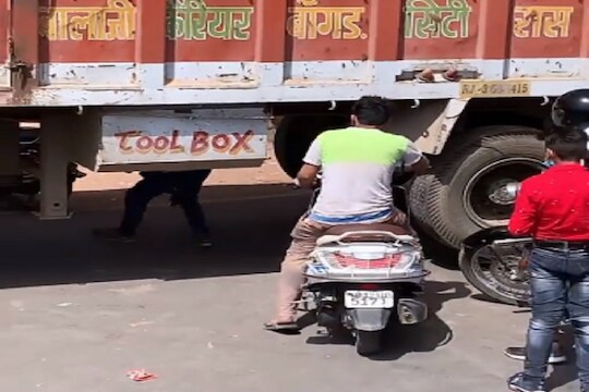 अरे यांना कुणीतरी आवरा! घाई म्हणून चक्क ट्रकखालूनच बाईक नेली; चालकाचा प्रताप VIRAL