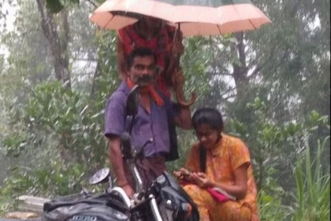 एक मुलगी ऑनलाईन क्लासच्या माध्यमातून आपला अभ्यास करत आहे. मात्र, तिच्या अभ्यासात अडथळा येऊ नये आणि ती भिजू नये यासाठी वडील तिच्या डोक्यावर छत्री धरून उभा (Father Holds Umbrella as Daughter Attends Online Class Amid Heavy rain) आहे.