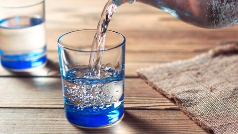 Glasses of water on a wooden table. Water was poured into the beaker. Selective focus. Shallow DOF