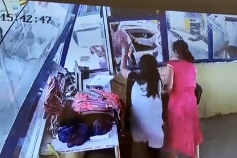 टोल बुथ बाहेर एक पांढरी कार उभी आहे, ज्यामधून एक व्यक्ती रागाने खाली उतरते आणि या महिलेच्या कानशिलात वाजवते.