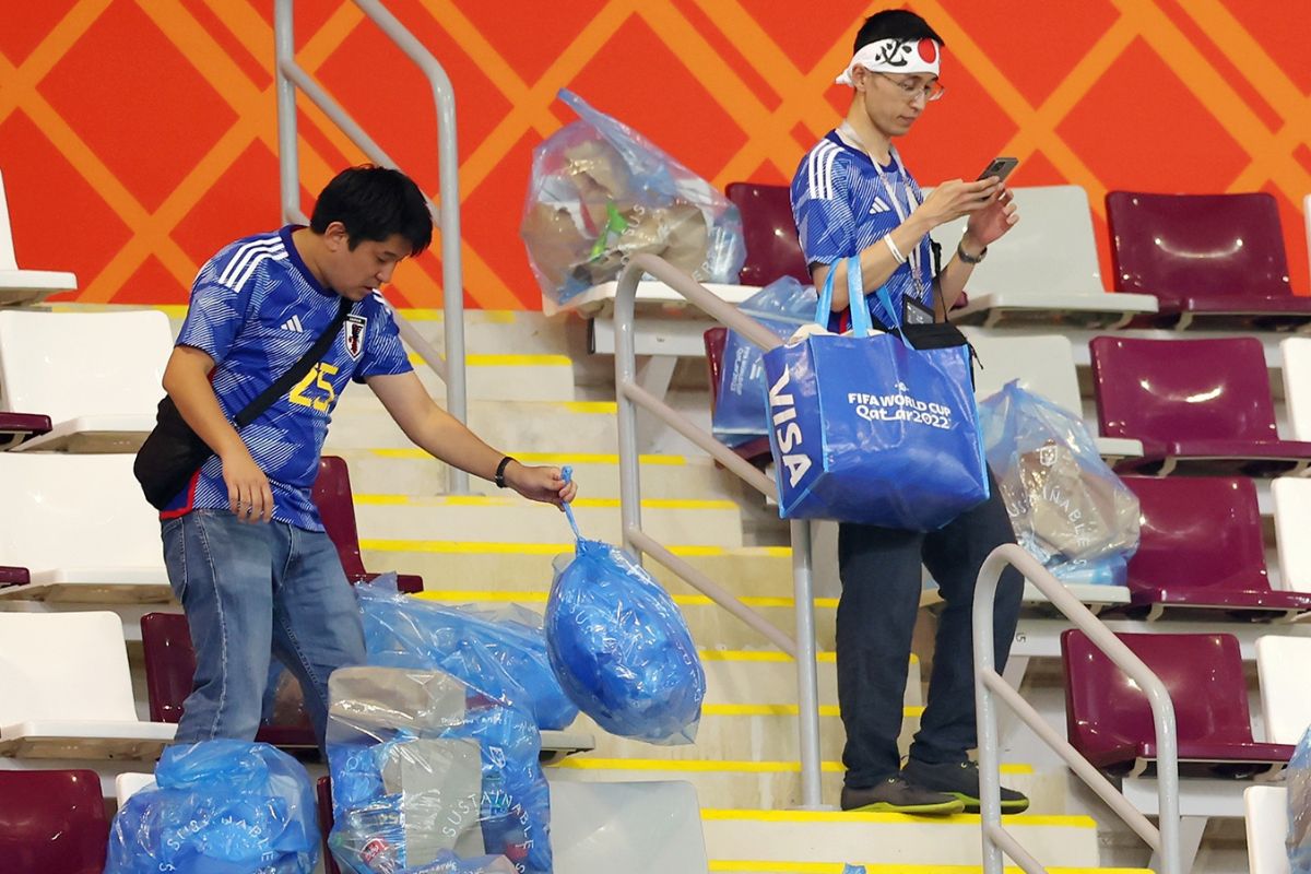 जपानी फुटबॉल चाहते स्टेडियम स्वच्छ करताना