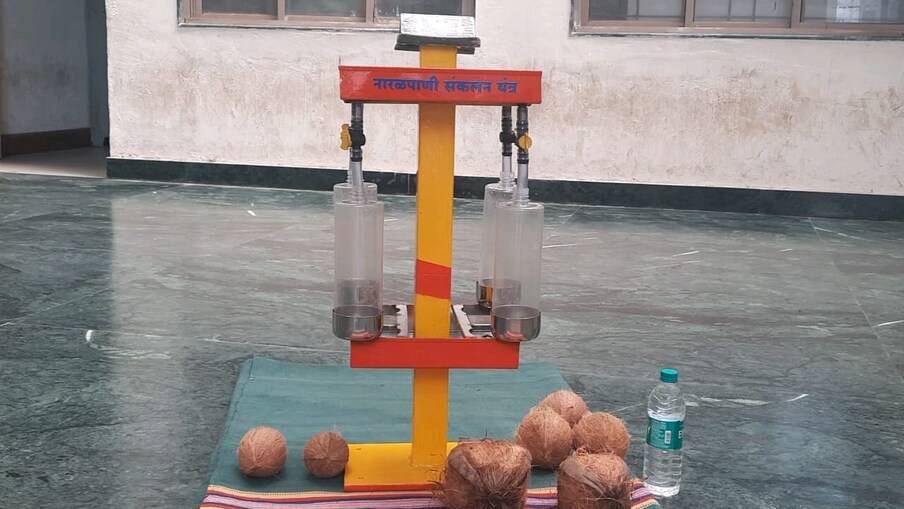 मशिनच्या वरच्या बाजूला वरच्या बाजूला नारळ वाढवण्यासाठी एक स्टीलचे बफिंग केलेला अँगल बसवण्यात आलेला आहे. त्याखाली एक ट्रे आहे.