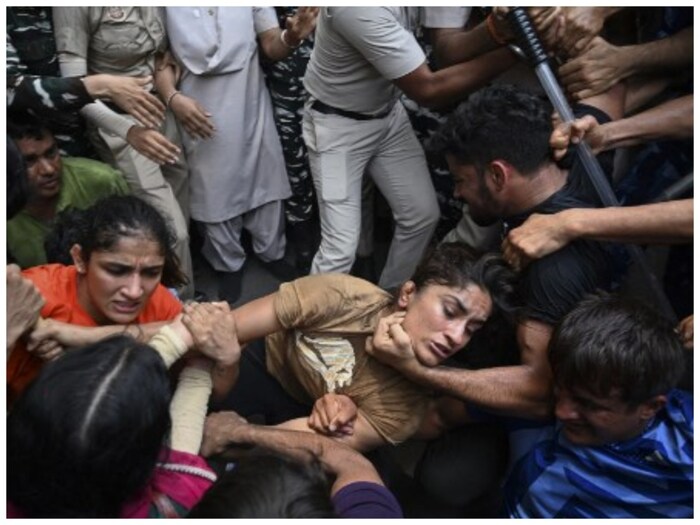 विनेश फोगट, साक्षी मलिक आणि बजरंग पुनिया यांच्यासह अनेक आंदोलनकर्त्या कुस्तीपटूंना सुरक्षा घेरा तोडून नवीन संसद भवनाकडे जाण्याचा प्रयत्न केल्याबद्दल दिल्ली पोलिसांनी अटक केली आहे. नवीन संसद भवनाजवळ कुस्तीपटूंनी महिला महापंचायतीचे नियोजन केले होते. (एएफपी)