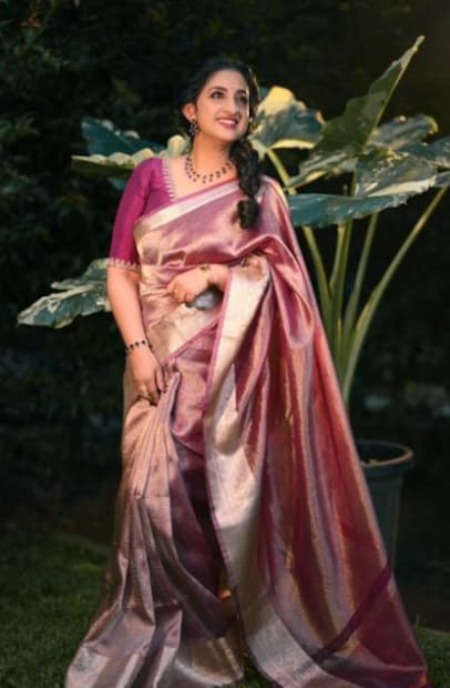  പർപ്പിൾ ഡ്യുവൽ ഷെയ്ഡ് ബനാറസി സാരിയാണ് സരിത ധരിച്ചിരുന്നത്. നെക്കിലും സ്ലീവ്സിലും ഹാൻഡ്‍വർക്ക് ചെയ്ത ഡീപ് പർപ്പിൾ കളർ ബ്ലൗസാണ് സാരിക്കൊപ്പം ധരിച്ചിരിക്കുന്നത്. മിനിമൽ മോക്കപ്പും സിംപിൾ ഹെയർ സ്റ്റെലുമാണ്. കമ്മലും മാലയും വളയുമാണ് ആക്സസറി.