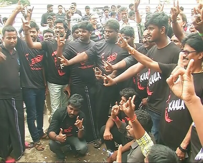  കാലാ ടീഷർട്ട് ധരിച്ച് ഫോട്ടോയ്ക്ക് പോസ് ചെയ്യുന്ന ആരാധകർ