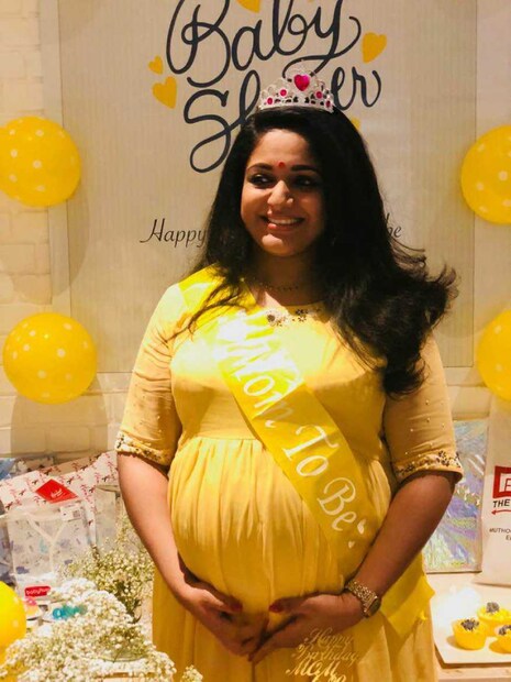  ബേബി ഷവർ ആഘോഷത്തിനിടെ ചിത്രത്തിന് പോസ് ചെയ്യുന്ന കാവ്യ