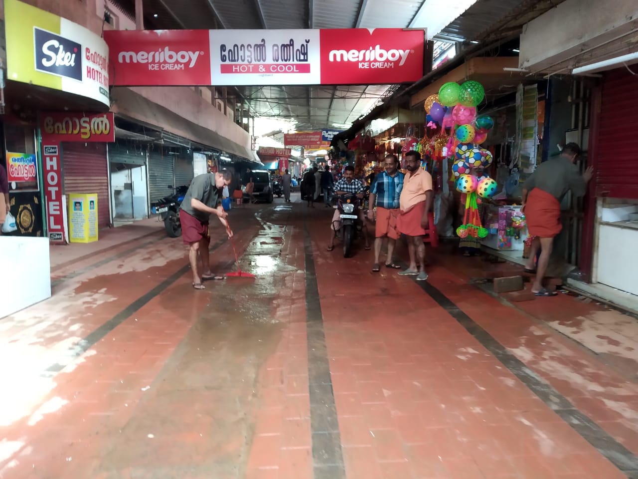  പറശ്ശിനി പുഴയിലെ വെള്ളം ഇറങ്ങിയതിനെ തുടർന് കച്ചവടക്കാർ കടകളും പരിസരവും വൃത്തിയാക്കുന്നു