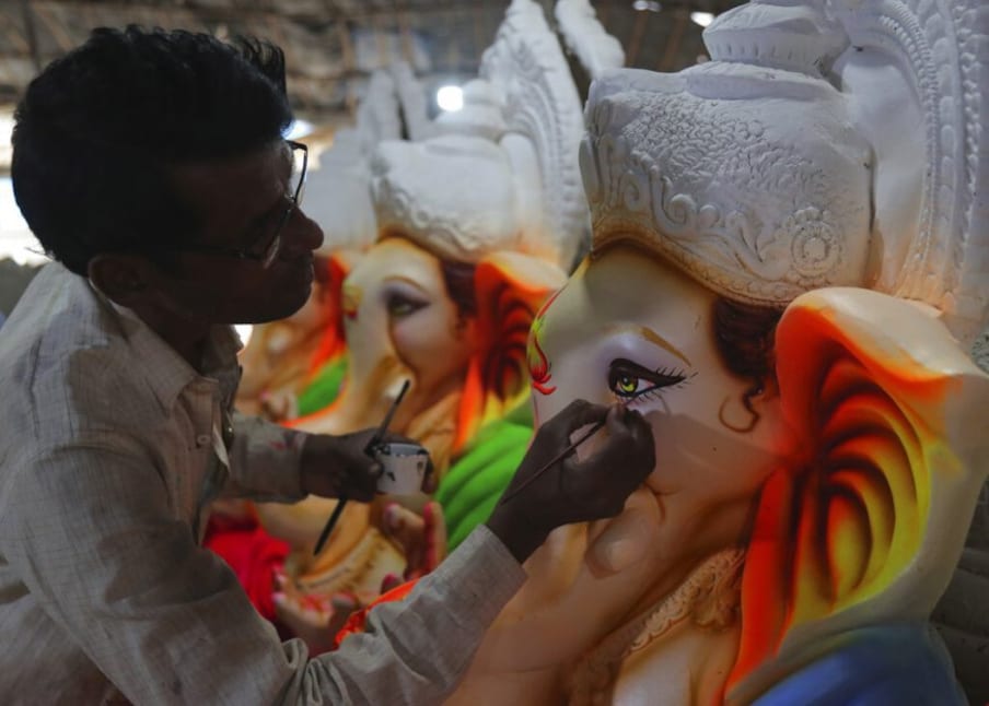  ഹൈദരാബാദിൽ ഗണേശ വിഗ്രഹത്തിൽ പെയിന്റിംഗ് ജോലികൾ പൂർത്തിയാക്കുന്ന കലാകാരൻ.  (Image: AP)