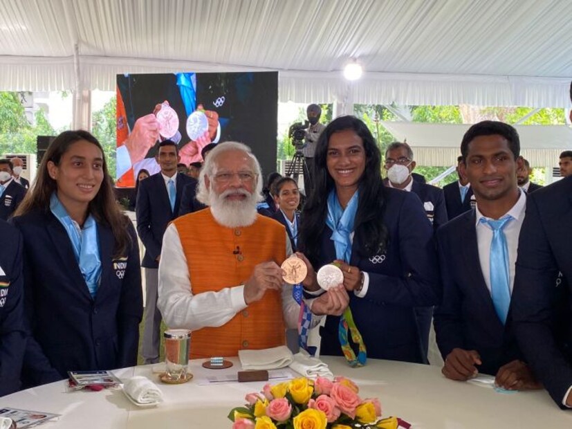  പി വി സിന്ധുവും പ്രധാനമന്ത്രി നരേന്ദ്ര മോദിയും ചിത്രത്തിനായി പോസ് ചെയ്യുന്നു; ടോക്യോ, റിയോ എന്നീ ഒളിമ്പിക്സുകളിൽ നിന്നും സിന്ധു നേടിയ മെഡലുകളും കാണാം (NaMo App Photo)