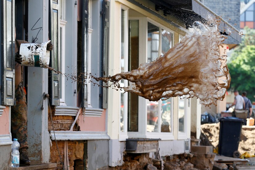 A soldier throws water out of a house, following heavy rainfalls, in Bad Muenstereifel, North Rhine-Westphalia state, Germany, on July 21. (Image: REUTERS/Thilo Schmuelgen)