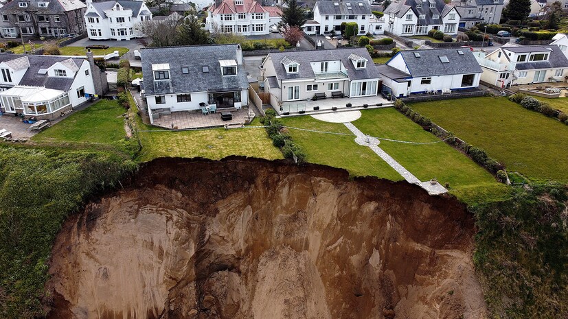 Houses are seen on the edge of a cliff after it collapsed in the village of Nefyn, Wales, in Britain, on April 20. (Image: REUTERS/Carl Recine)