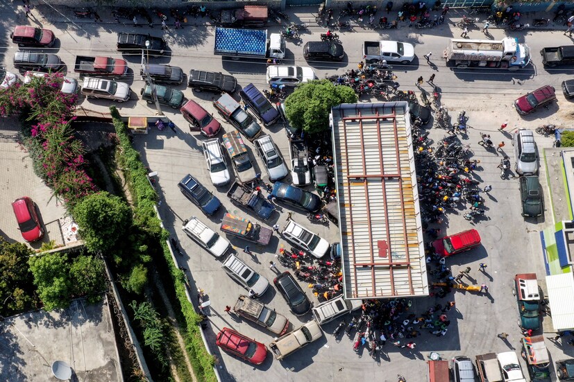 Cars line up as people wait with motorcycles and plastic containers at a gas station amid a nationwide shortage of fuel, in Port-au-Prince, Haiti, on October 31. (Image: REUTERS/Ralph Tedy Erol)