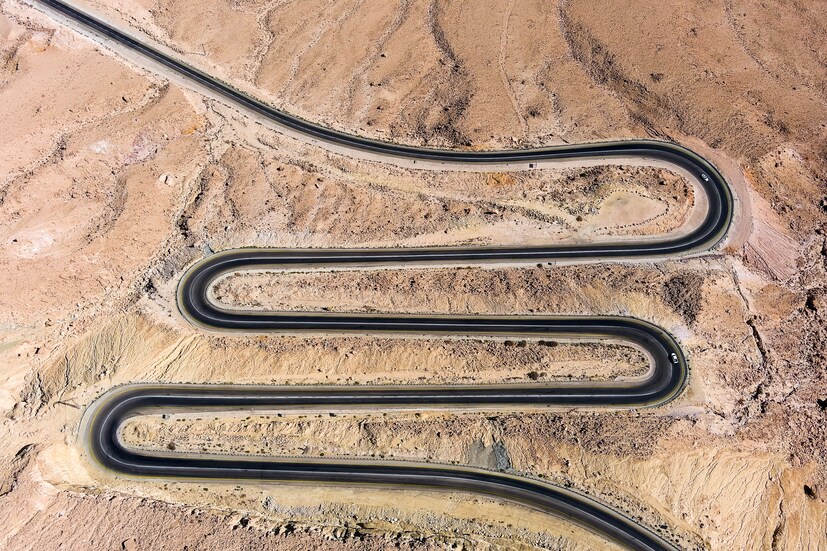 Cars drive on a road that leads from the Israeli town of Mitzpe Ramon into the Ramon crater in the Negev desert, southern Israel, on October 22. (Image: REUTERS/ Ilan Rosenberg)