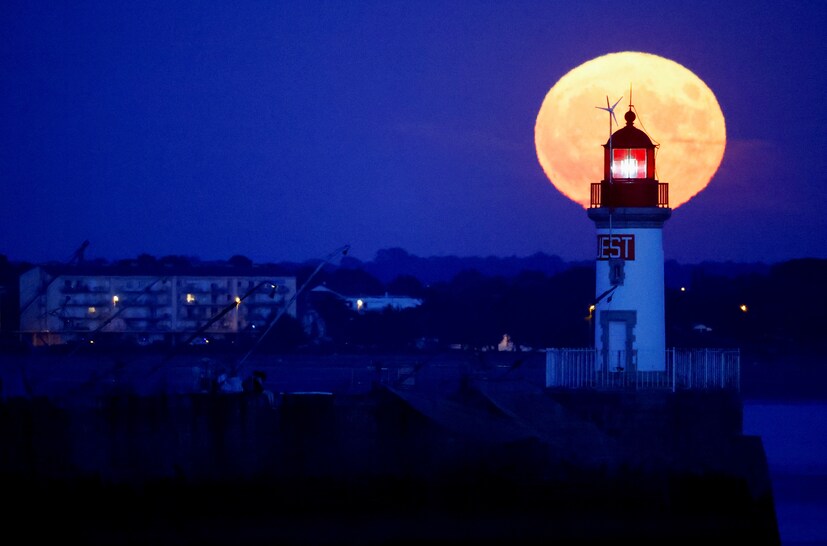 FRANCE: Buck Moon is seen behind a lighthouse in Saint-Nazaire, France. (Image: Reuters)