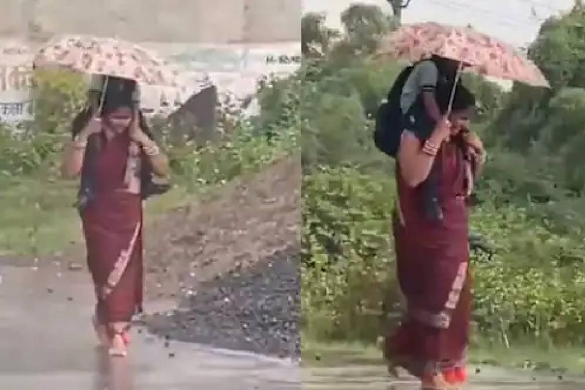 മകളെ തോളിലേന്തി ഒരു കയ്യിൽ കുടയും പിടിച്ചു നടക്കുന്ന അമ്മയെ വീ‍ഡിയോയിൽ കാണാം