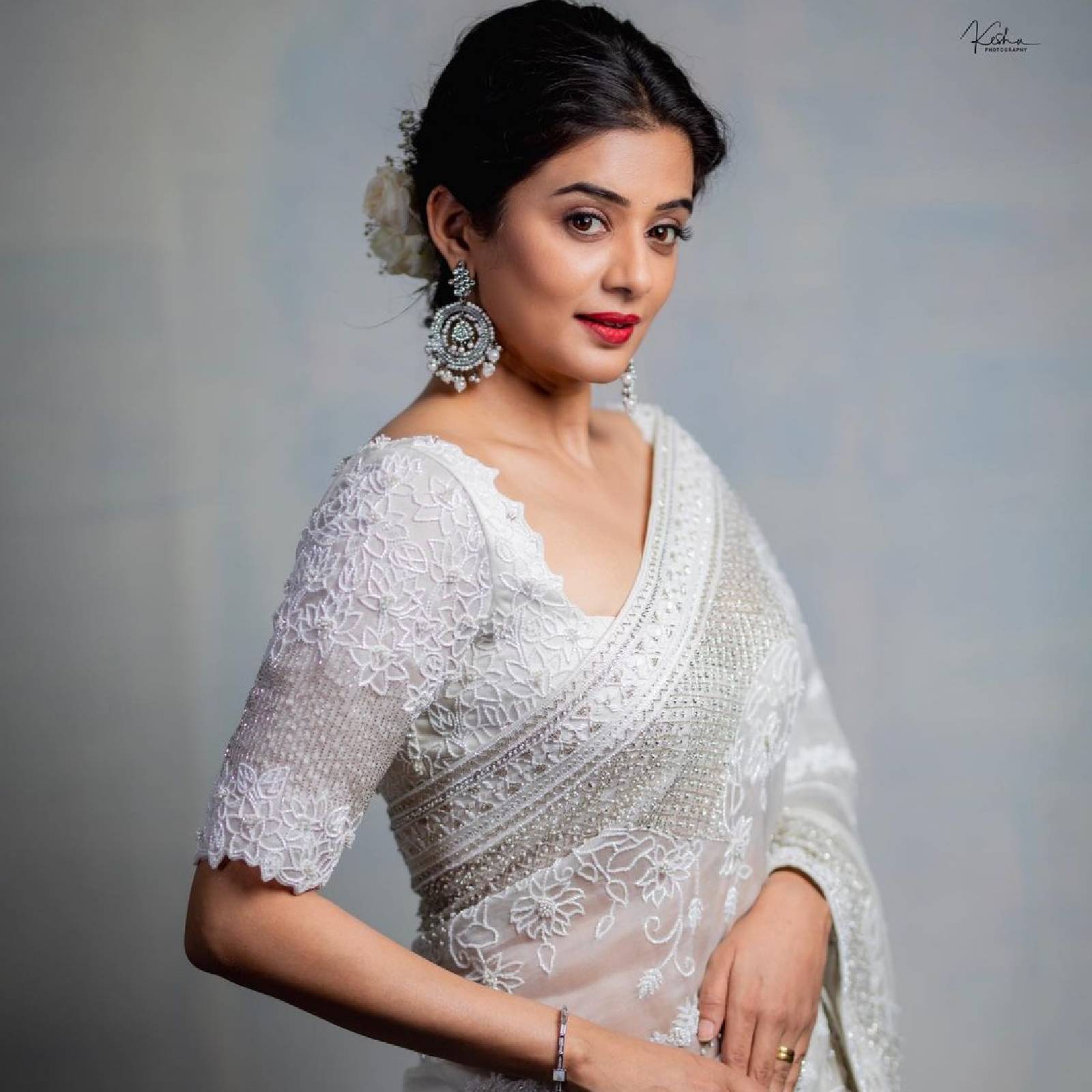  സാരിക്കു ചേരുന്ന തരത്തിലുളള സില്‍വര്‍ നിറത്തിലുള്ള വലിയ കമ്മലുകളാണ് ധരിച്ചിരിക്കുന്നത്. പുട്ടപ്പ് ചെയ്ത ഹെയര്‍ സ്റ്റൈലില്‍ വെളുത്ത നിറത്തിലുള്ള പൂക്കള്‍ കൊണ്ട് അലങ്കരിച്ചിട്ടുണ്ട്.