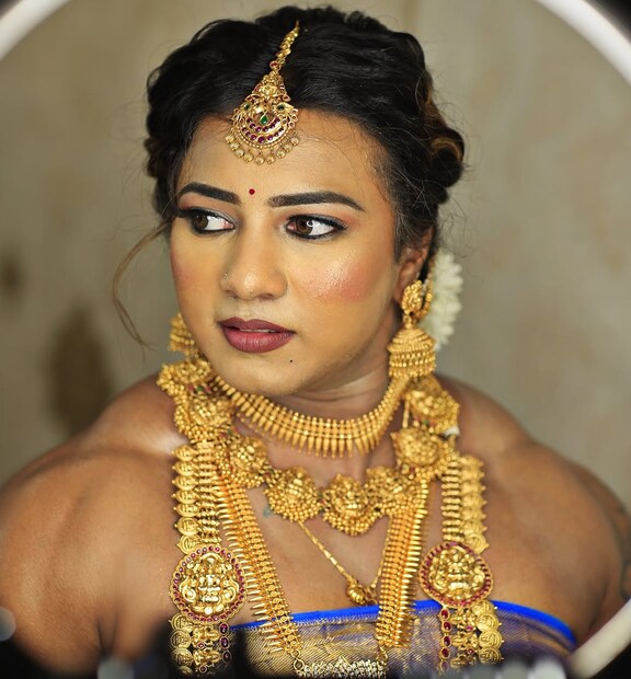  ഞ്ഞയും നീലയും കലര്&#x200d;ന്ന വര്&#x200d;ണത്തിലുള്ള കാഞ്ചീവരം സാരിയിലാണ് ചിത്രങ്ങളില്&#x200d; വധുവിനെ കാണുന്നത്. ബ്ലൗസ് ധരിക്കാതെ തോളും ബൈസെപ്സും എടുത്തുകാട്ടുന്ന രീതിയിലായിരുന്നു വസ്ത്രധാരണം. കഴുത്തിൽ സ്വര്&#x200d;ണാഭരണങ്ങളുടെ വലിയ നിര തന്നെയുണ്ട്. കമ്മലുകളും വളകളും അഴക് കൂട്ടുന്നു. ഐലൈനറാൽ മനോഹരമാക്കപ്പെട്ട കണ്ണുകൾ‌, ഗജ്ര കൊണ്ട് പിന്നിയിട്ട മുടി, ചുവന്ന ലിപ്സ്റ്റിക് എന്നിവയും ചിത്രയുടെ കരുത്തിന് ചേരുന്നവിധത്തിലായിരുന്നു. (image: chitra_purushotham/ instagram)