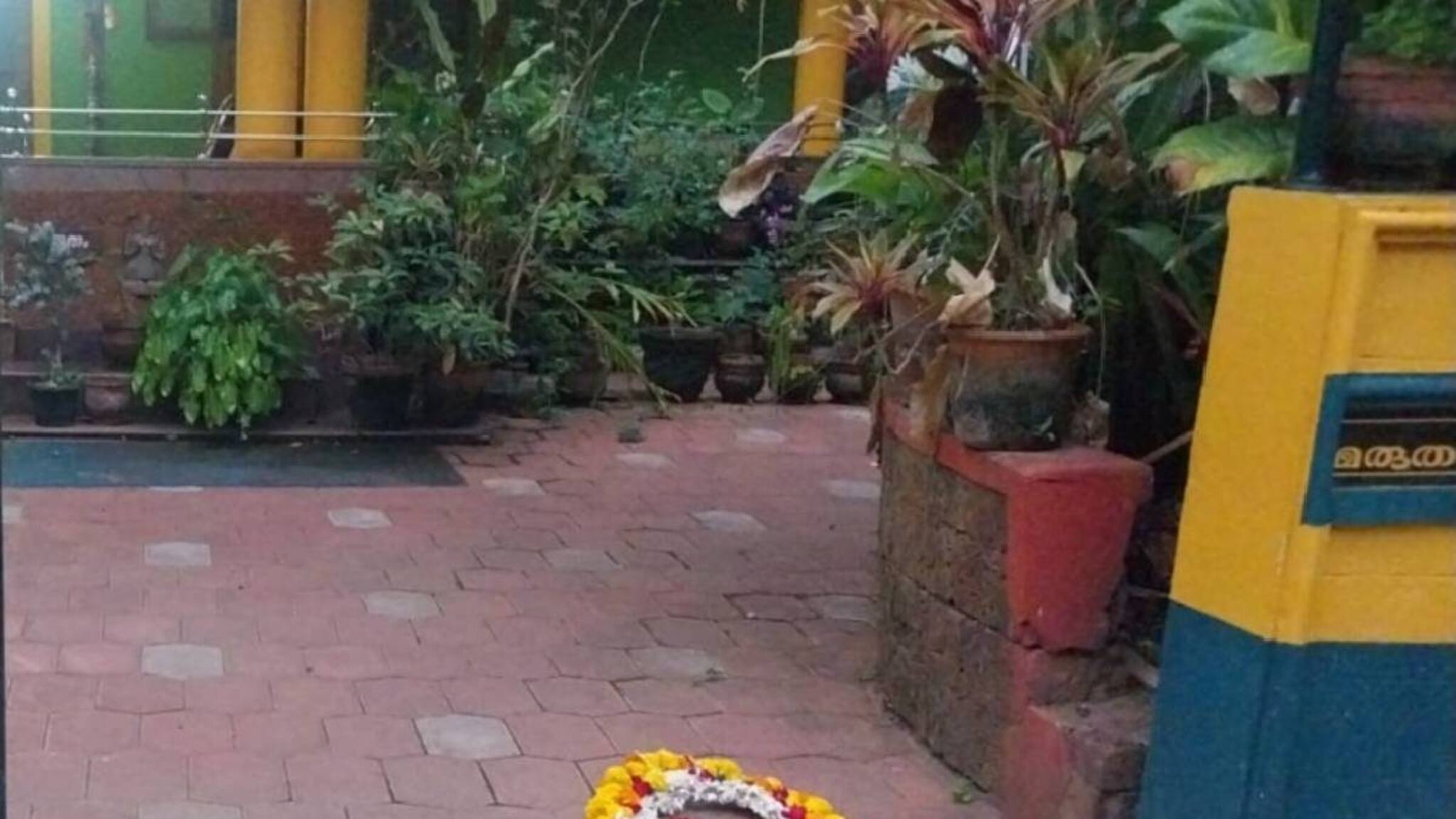 പയ്യന്നൂരിൽ ‌വി കുഞ്ഞിക്കൃഷ്ണന്റെ പുസ്തകം ഏറ്റുവാങ്ങിയ എഴുത്തുകാരന്റെ കണ്ണൂരിലെ വീടിനു മുന്നിൽ റീത്ത്