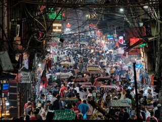 Bustling crowded street of Matia Mahal Road near Jama Masjid at night during weekend. The road is lined with people and vehicles jostling for a space. Copyright (c) 2023 Wan Kum Seong/Shutterstock.