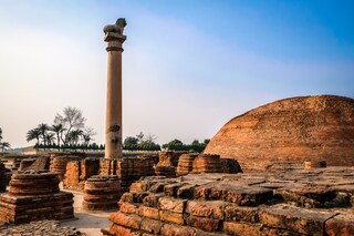 Pillars of Ashoka with blue sky at Vaishali in Bihar, India. Beautiful scenic view of monument ancient with lion pole top in summer day. Copyright (c) 2018 Mut Hardman/Shutterstock.