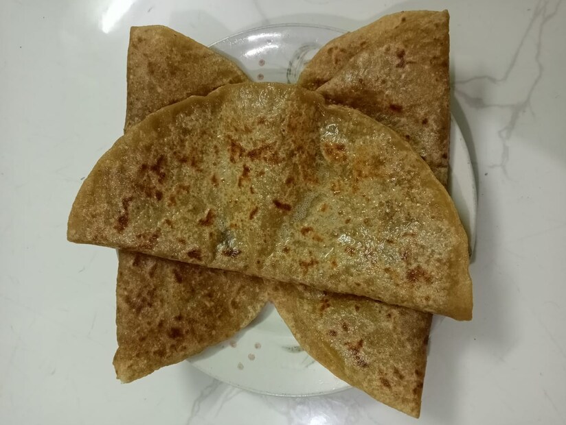 आता कणकेचा गोळा थोडासा लाटून घेऊन त्यात सोजीचा गोळा टाकून चांगलं बंद करायचं आहे. अगदी पुरणपोळीप्रमाणे ही पोळी लाटून घ्यायची आहे. तव्यावर दोन्ही साईडने तेलाने चांगली फ्राय करून घेतल्यानंतर गरमागरम सर्व्ह करायची आहे.