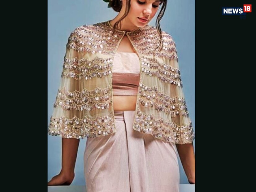 केप स्टाईल ब्लाउज : तुम्ही थोडेसे प्रयोगशील असाल आणि तुमच्या वधूच्या लूकमध्ये काहीतरी नवीन जोडू इच्छित असाल, तर केप-स्टाईल ब्लाउज वापरून पाहा. हा ब्लाउज खांद्यावरून फ्लोइंग केपसह येतो, जो एकूण लूकला एक रॉयल टच देतो. सिक्विन्स, मिरर वर्क किंवा मणींनी सजवलेला, हा ब्लाउज रिसेप्शन किंवा संगीत समारंभांसारख्या फंक्शन्समध्ये आकर्षक दिसतो.