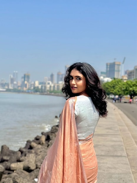 या फोटोशूटमध्ये रिंकूने फिकट केशरी रंगाची कॉटन साडी परिधान केली आहे. साधा मेकअप, हलकं जुळं बांधलेले केस आणि साडीचा पारंपरिक लूक तिच्या व्यक्तिमत्त्वाला वेगळाच चार्म देतो. समुद्रकिनाऱ्यावर बसून घेतलेले हे फोटो तिच्या नैसर्गिक सौंदर्याला अधिक उठाव देतात. 