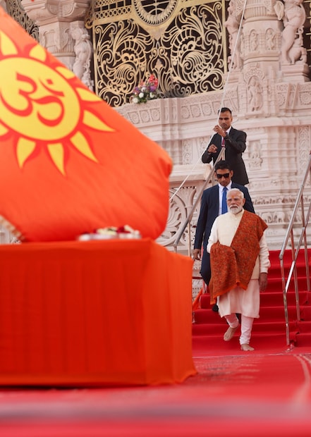 6. मंदिर संकुलातील कलात्मक वातावरणदगडावरील कोरीवकाम आणि कांस्य ढाल यांच्यामध्ये ध्वज आणखी खास आणि उठून दिसत आहे.
