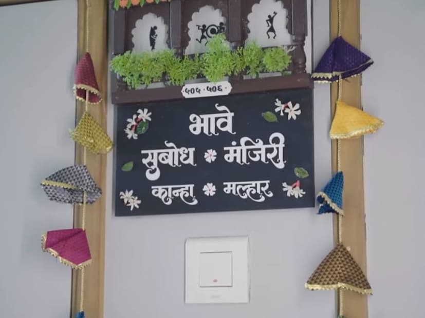  सुबोध भावे आणि मंजिरी भावे यांच्या घरात एन्ट्री करण्यापूर्वी लक्ष वेधून घेते ती त्यांची आकर्षक नेमप्लेट. काळ्या रंगाच्या नेमप्लेटवर भावे सुबोध, मंजिरी,कान्हा आणि मल्हार असे पांढऱ्या अक्षरात मराठीत लिहिलेलं आहे. तर त्यावर प्राजक्ताची फुलंदेखील आहेत. नेमप्लेट अधिक आकर्षक करण्यासाठी बाजूला खणाचं तोरण बांधलेलं आहे.