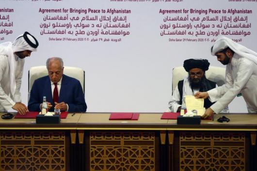 Mullah Abdul Ghani Baradar, the leader of the Taliban delegation, signs an agreement with Zalmay Khalilzad, U.S. envoy for peace in Afghanistan, at a signing agreement ceremony between members of Afghanistan's Taliban and the U.S. in Doha, Qatar. (Reuters)