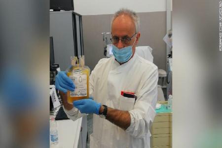 Doctor Cesare Perotti, director of the immunotransfusion service at the University of Pavia San Matteo Hospital, holds a bag of plasma after a donation. (Image: CNN)