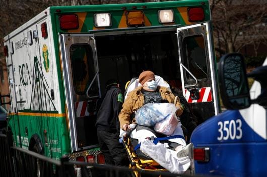 A patient wears a protective face mask as she is loaded into an ambulance at The Brooklyn Hospital Center emergency room, Wednesday, March 18, 2020, in New York. (AP Photo/John Minchillo) A patient wears a protective face mask as she is loaded into an ambulance at The Brooklyn Hospital Center emergency room, Wednesday, March 18, 2020, in New York. (AP Photo/John Minchillo)