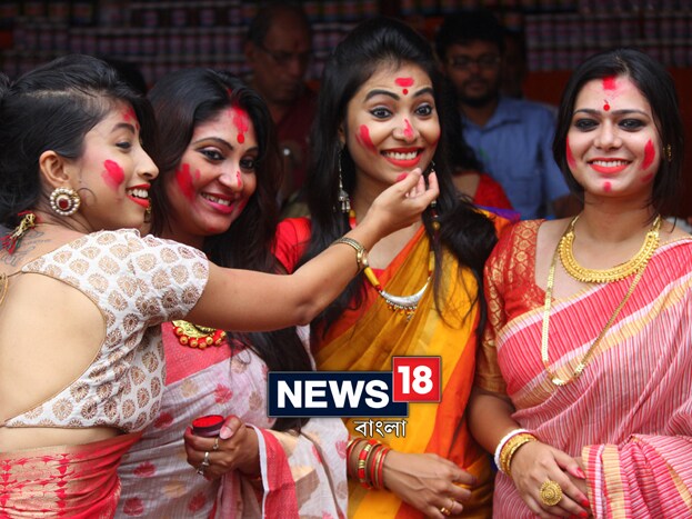 দশমীর দিন কেন এই পুজোর আলাদা গুরুত্ব, সেটা মণ্ডপে প্রবেশ করলেই বোঝা যাবে ৷ লাল-পাড় সাদা শাড়ি পরে বরণের ডালা হাতে লাইনে দাঁড়িয়ে অসংখ্য মহিলা ৷ কিন্তু সিঁদুর খেলার জন্য শুধুই কি সধবাদের ভিড় সেখানে ? বাঙালির ট্র্যাডিশনাল সাজে কম বয়সী মেয়েদের ভিড়ই যে বেশি চোখে পড়বে ! Photo: Siddhartha Sarkar দশমীর দিন কেন এই পুজোর আলাদা গুরুত্ব, সেটা মণ্ডপে প্রবেশ করলেই বোঝা যাবে ৷ লাল-পাড় সাদা শাড়ি পরে বরণের ডালা হাতে লাইনে দাঁড়িয়ে অসংখ্য মহিলা ৷ কিন্তু সিঁদুর খেলার জন্য শুধুই কি সধবাদের ভিড় সেখানে ? বাঙালির ট্র্যাডিশনাল সাজে কম বয়সী মেয়েদের ভিড়ই যে বেশি চোখে পড়বে ! Photo: Siddhartha Sarkar