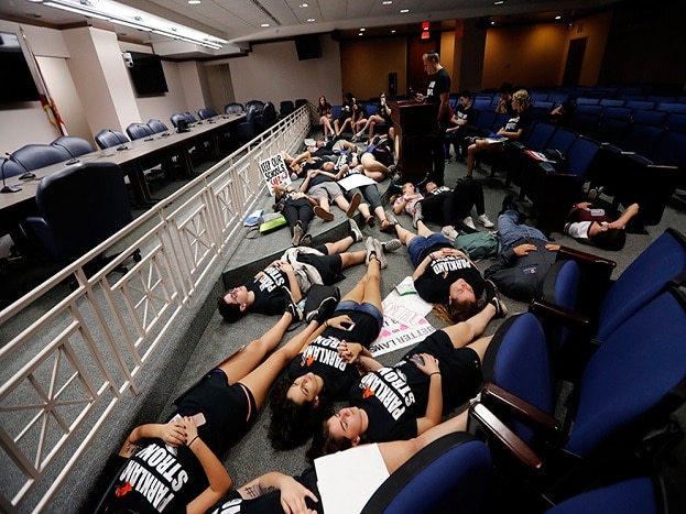 Seventeen student survivors from Marjory Stoneman Douglas High School lie down on the floor in silence and pray at the approximate time of the attack one week ago, inside the state capitol, in Tallahassee. (Image: AP) Seventeen student survivors from Marjory Stoneman Douglas High School lie down on the floor in silence and pray at the approximate time of the attack one week ago, inside the state capitol, in Tallahassee. (Image: AP)
