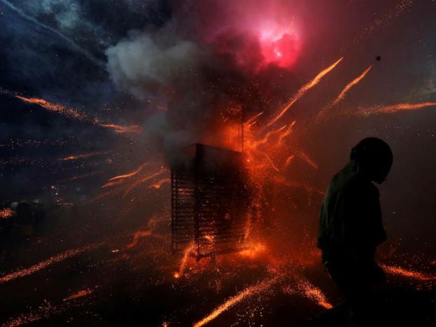 A participant wearing a motorcycle helmet gets sprayed with firecrackers, during the Beehive Firecrackers festival at the Yanshui district in Tainan, Taiwan (Image: REUTERS) A participant wearing a motorcycle helmet gets sprayed with firecrackers, during the Beehive Firecrackers festival at the Yanshui district in Tainan, Taiwan (Image: REUTERS)