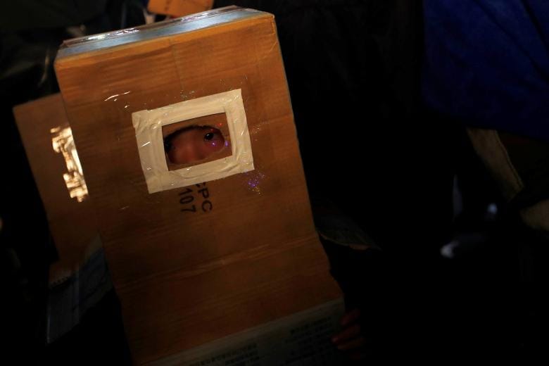 A child takes cover inside a cardboard box, during the 'Beehive Firecrackers' festival at the Yanshui district in Tainan, Taiwan. (Image: REUTERS) A child takes cover inside a cardboard box, during the 'Beehive Firecrackers' festival at the Yanshui district in Tainan, Taiwan. (Image: REUTERS)