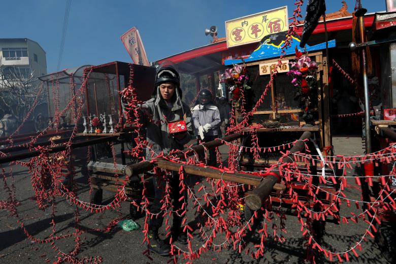 A worshipper put firecrackers on palanquin which would be carrying statues of Guan Gong, the Chinese God of War, during 'Beehive Firecrackers' festival at the Yanshui district, in Tainan, Taiwan. (Image: REUTERS) A worshipper put firecrackers on palanquin which would be carrying statues of Guan Gong, the Chinese God of War, during 'Beehive Firecrackers' festival at the Yanshui district, in Tainan, Taiwan. (Image: REUTERS)
