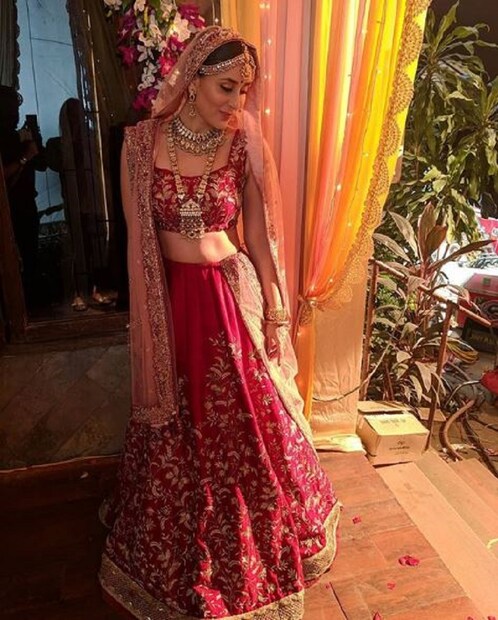 লাল লেহঙ্গা মাথায় চুনরি গা ভরা গয়নায় ৷ লাস্য মাখা দাঁড়িয়ে থাকা করিনা ৷ Photo Courtesy - poonamdamania / Instagram Handle 