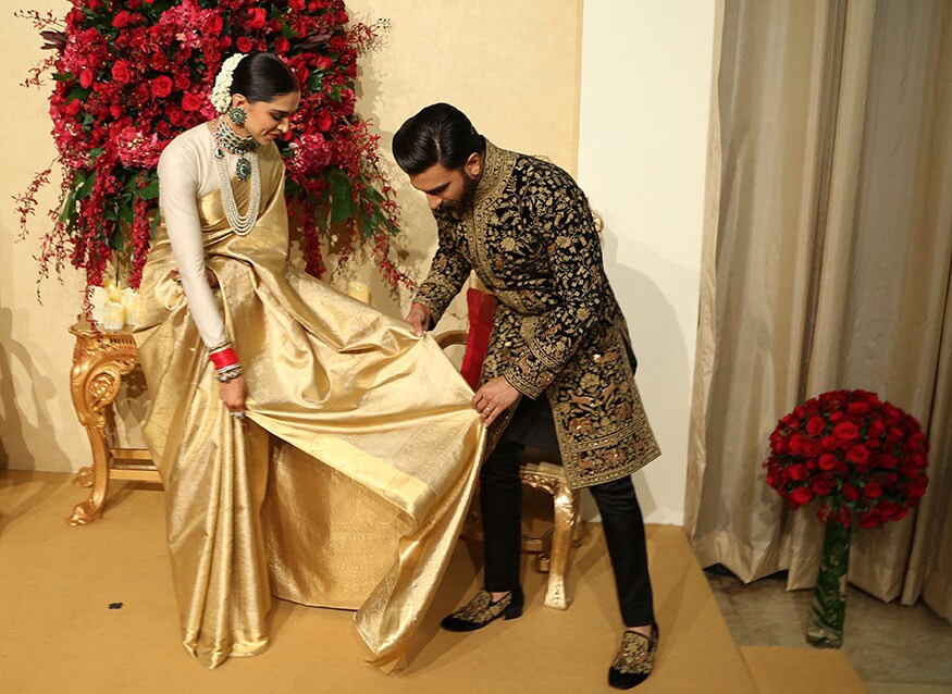 শাড়ির আঁচল নিয়ে একটু সমস্যায় পড়েন দীপিকা। মুহূর্তের মধ্যে সব কেতাদুরস্ত ভাব কাটিয়ে ভুলে এগিয়ে আসেন রণবীর। ঠিক করে দেন দীপিকার শাড়ির আঁচল। (Image: AP) শাড়ির আঁচল নিয়ে একটু সমস্যায় পড়েন দীপিকা। মুহূর্তের মধ্যে সব কেতাদুরস্ত ভাব কাটিয়ে ভুলে এগিয়ে আসেন রণবীর। ঠিক করে দেন দীপিকার শাড়ির আঁচল। (Image: AP)