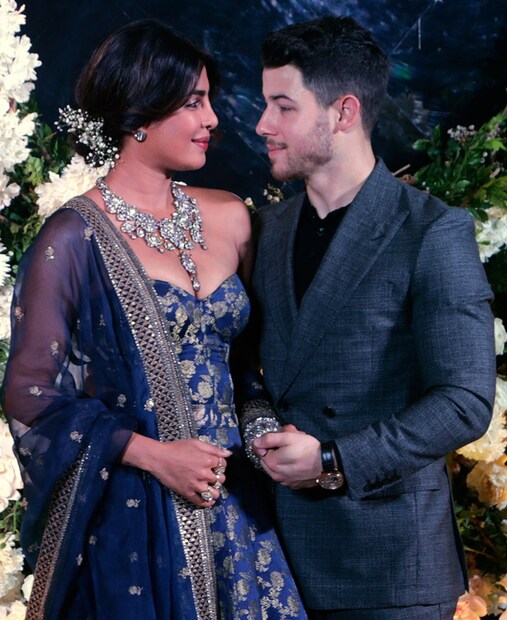 এই রিসেপশনের জন্য প্রিয়াঙ্কা বেছেছিলেন ব্লু অফ শোল্ডার সব্যসাচী আনারকলি৷ ব্রোকেডে আনারকলির সঙ্গে ছিল নীল সিফন ওড়না৷