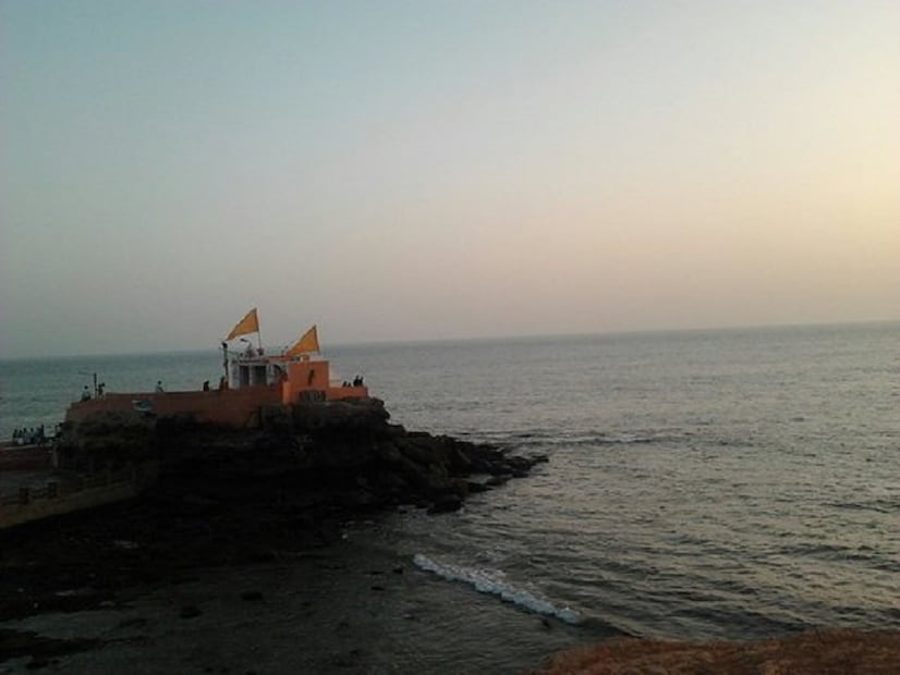  ♦ শুধুমাত্র মন্দিরের ২০ ফুট লম্বা পাথরের তৈরি থামটির উপরের অংশ ও মন্দিরের ধ্বজাটি দেখা যায়। আবার দুপুর ১টার পর মন্দিরের উপর থেকে জল নামতে শুরু করে। দর্শনার্থীরা একে একে আসতে শুরু করেন। ছবি: সংগৃহীত ৷