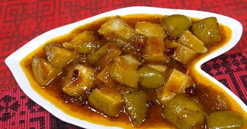 কাঁচা আমের তরকারি বানাতে---প্রথমে আম খোসাসুদ্ধ বড় টুকরোয় কেটে নিন। প্যানে তেল গরম করে সর্ষে, জিরে, হিং, হলুদগুঁড়ো আর গোটা শুকনো লঙ্কা ফোড়ন দিন। সর্ষে আর জিরে ফুটতে শুরু করলে আমের টুকরো মেশান। চিনি আর জল দিয়ে ১০-১৫ মিনিট ফুটতে দিন। আম পুরোপুরি সেদ্ধ হয়ে ঝোল গাঢ় হলে নামিয়ে নিন। গরম গরম বা ফ্রিজে রেখে ঠান্ডা করেও খেতে পারেন।  Photo Source: Collected